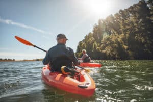 Mature man and woman in individual kayaks.