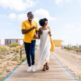 Mature couple walking along the beach boardwalk.