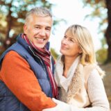 Handsome, mature couple embracing in the woods.