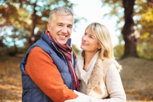 Handsome, mature couple embracing in the woods.